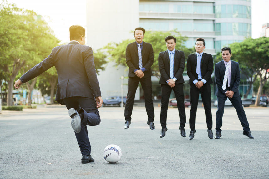 五个身穿西服的亚洲男士在户外踢足球     亚洲商务人士休闲生活实拍图