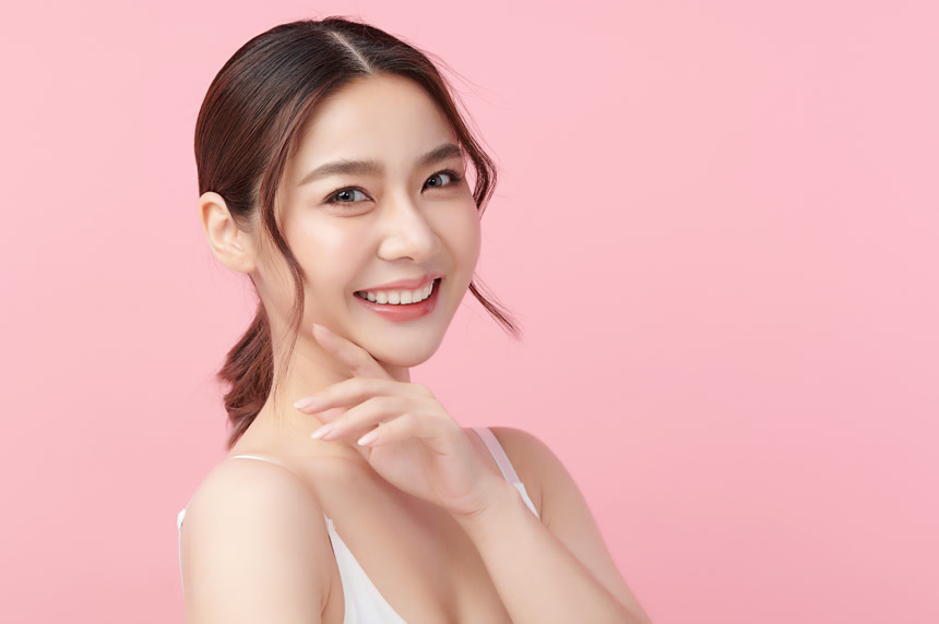 年轻美丽的亚洲女人，皮肤清澈，粉红背景，面部护理，面部护理，美容，美容美发，水疗，亚洲女性肖像.