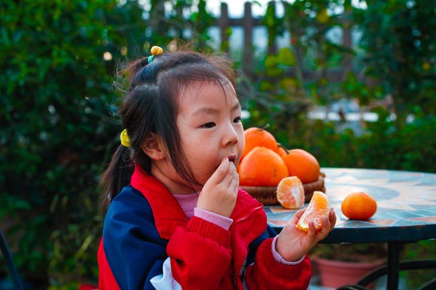 小孩正在吃着蜜桔