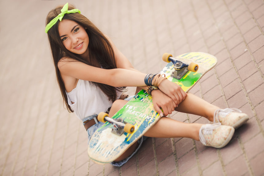 年轻女子拿着滑板坐在地上人像背景壁纸