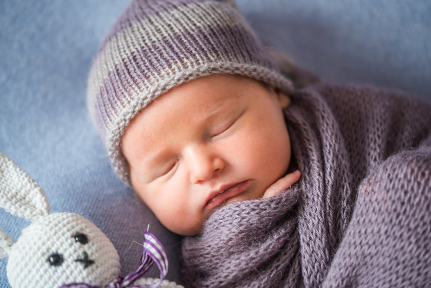 小睡新生儿用紫色的毛巾包裹着正在睡觉生活方式婴幼儿宣传