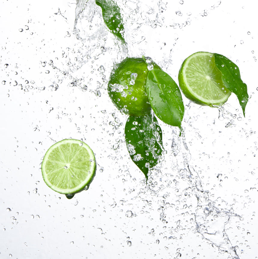 新鲜绿色柠檬和飞溅的水柠檬汁广告