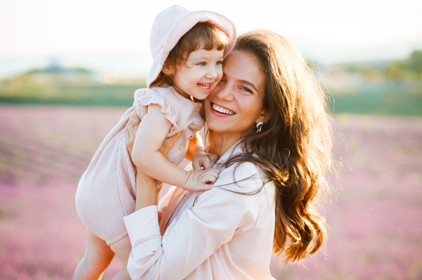 母亲托举着女儿看着镜头开心的笑了起来