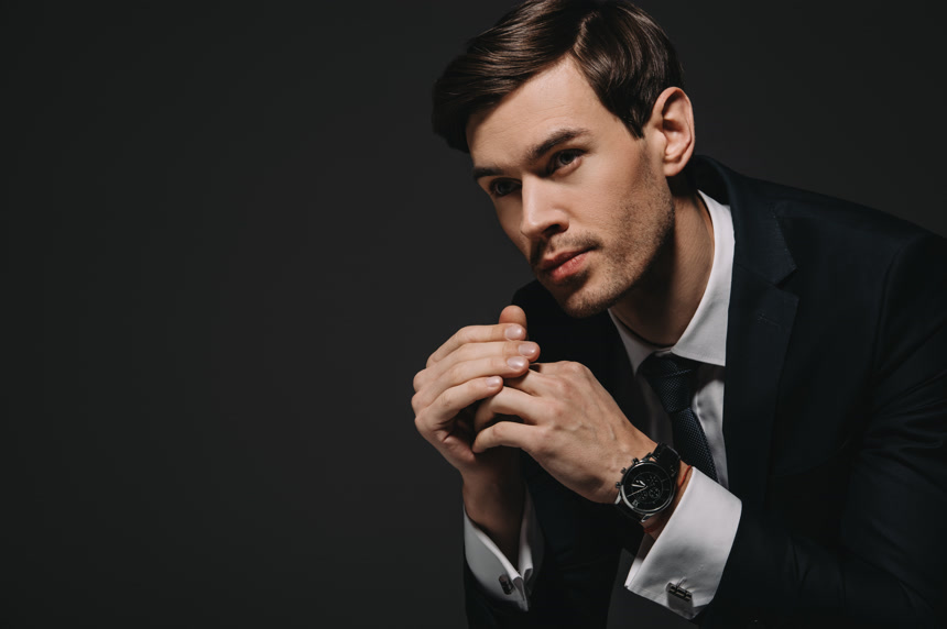 英俊的商人在西装在黑色背景