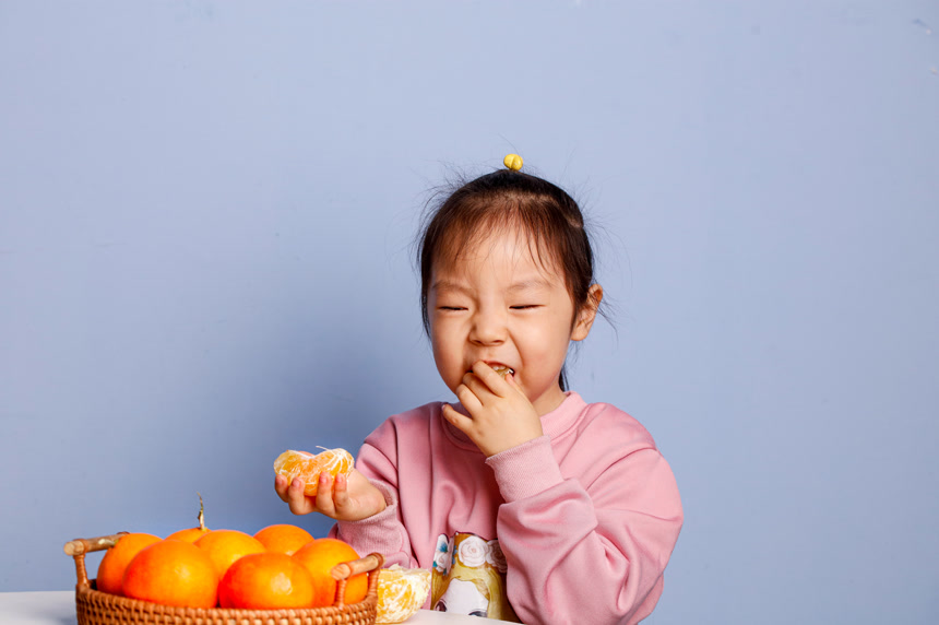 小孩正在吃着蜜桔