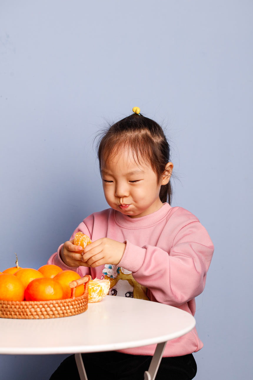 小孩正在吃着蜜桔
