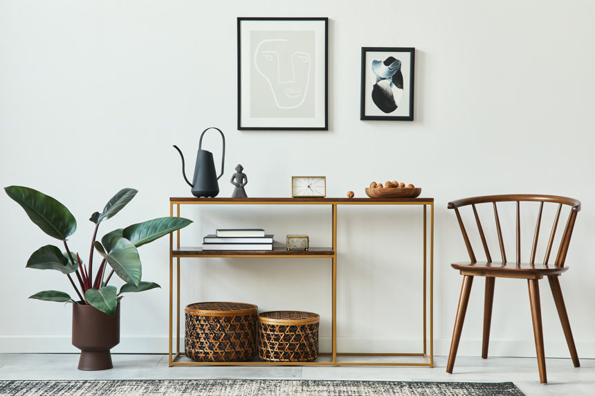 客厅室内装潢的时尚理念，家居装饰中，有仿制的海报框架、木制控制台、椅子、植物、藤篮、植物、地毯生活方式