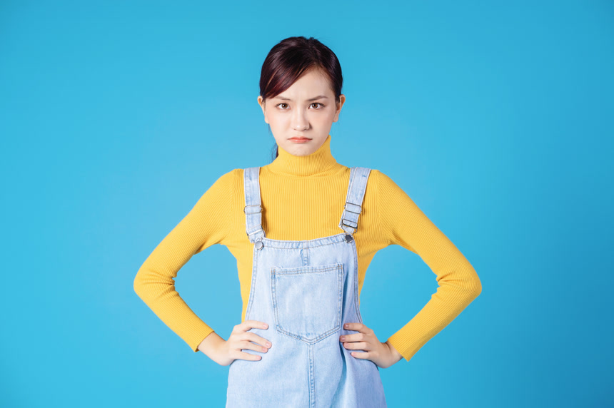 蓝色背景的年轻亚洲女孩生气表情生活方式