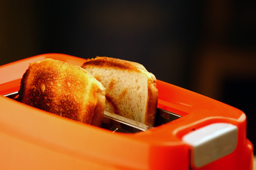 橙色烤面包机上有两片土司特写  产品宣传图