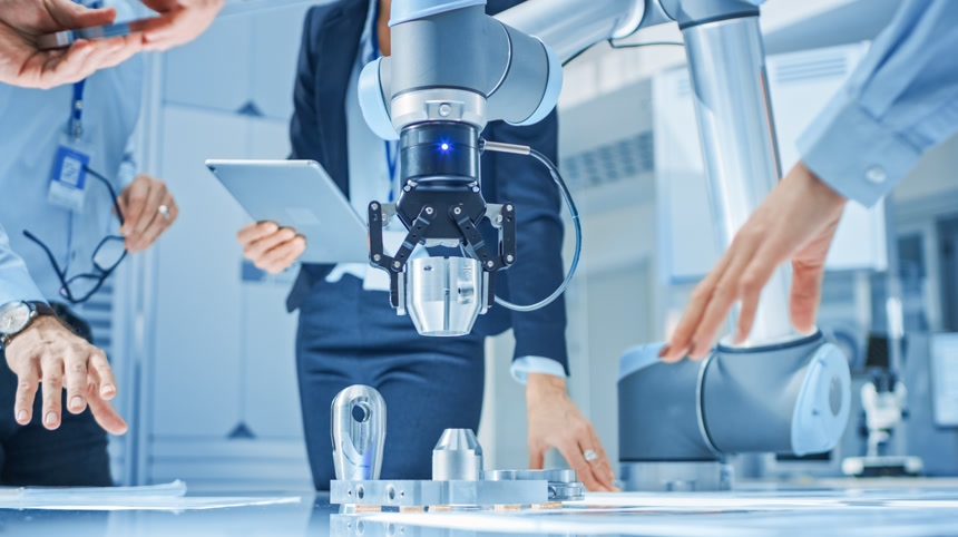 工业机器人工程师团队与机器人手臂聚集在桌子周围，他们使用平板电脑操作和编程，以拾取和移动金属组件。现代科技机器人操作