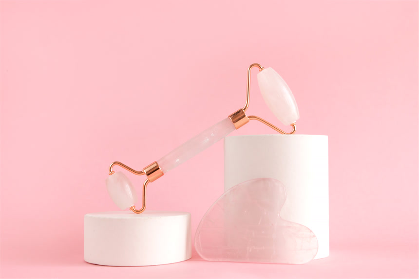 玫瑰石英滚筒，用于在混凝土讲台上进行面部按摩。美容美发和家庭皮肤护理的概念.抗衰老治疗美容护肤