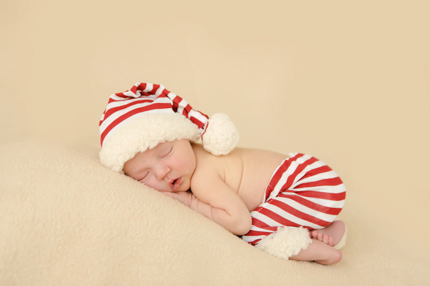 刚出生的婴儿戴着圣诞老人帽子睡觉儿童写真
