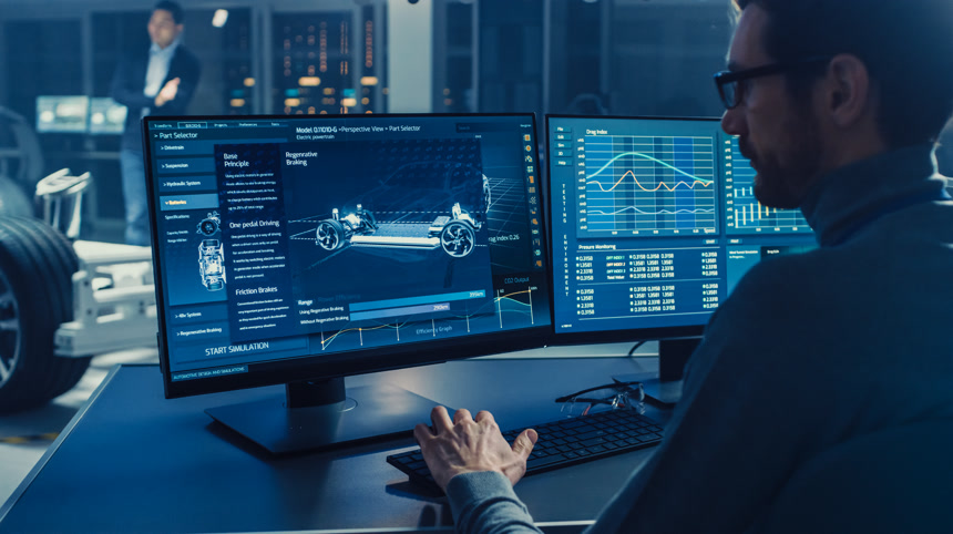 专业工程师使用 3d Cad 软件在计算机上工作，并在高科技开发实验室中测试电动汽车底盘原型，并配有车轮、电池和发动机.工业生产汽车设计