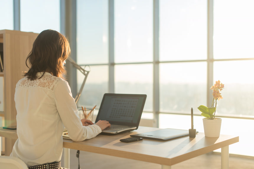 商务女人在家里使用的便携式计算机工作