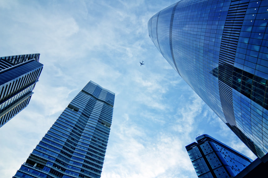 仰拍蓝天飞 机城市建筑公司商务大楼一角航空物流