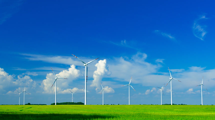 在绿地上的风车在阳光灿烂多风的日子里蓝天白云