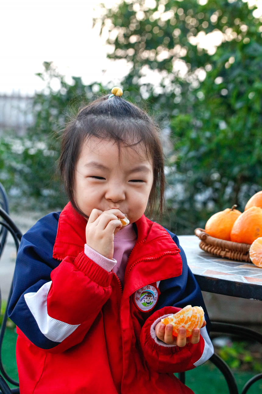 小孩正在吃着蜜桔