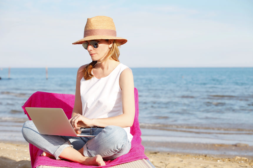 女人使用笔记本在海边办公