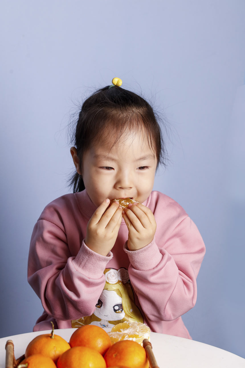 小孩正在吃着蜜桔