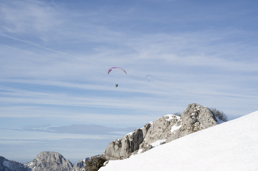 冬天日落时滑翔伞在山上滑翔度假休闲娱乐