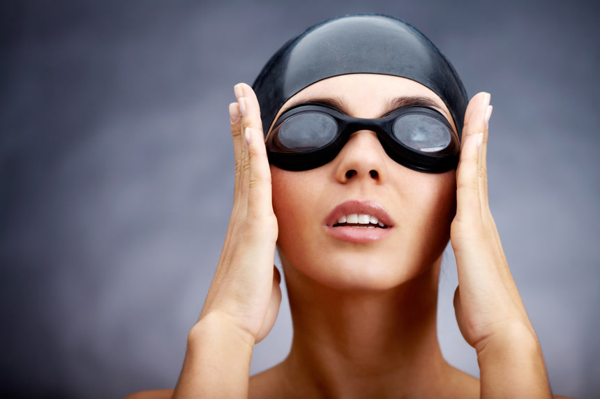 灰色背景带泳镜的女游泳选手