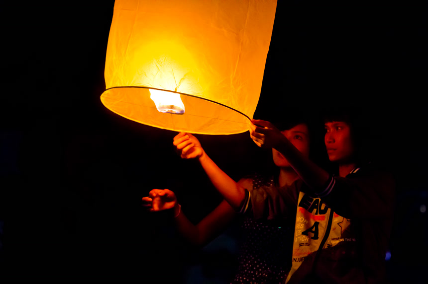 两人夜晚放飞孔明灯节日祝愿