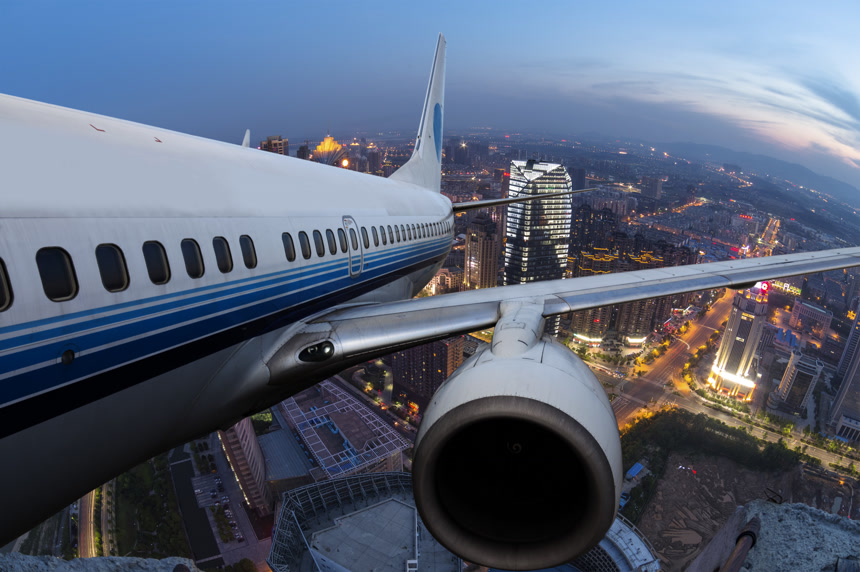 飞机在黑夜里飞行在城市的上空非常震撼 