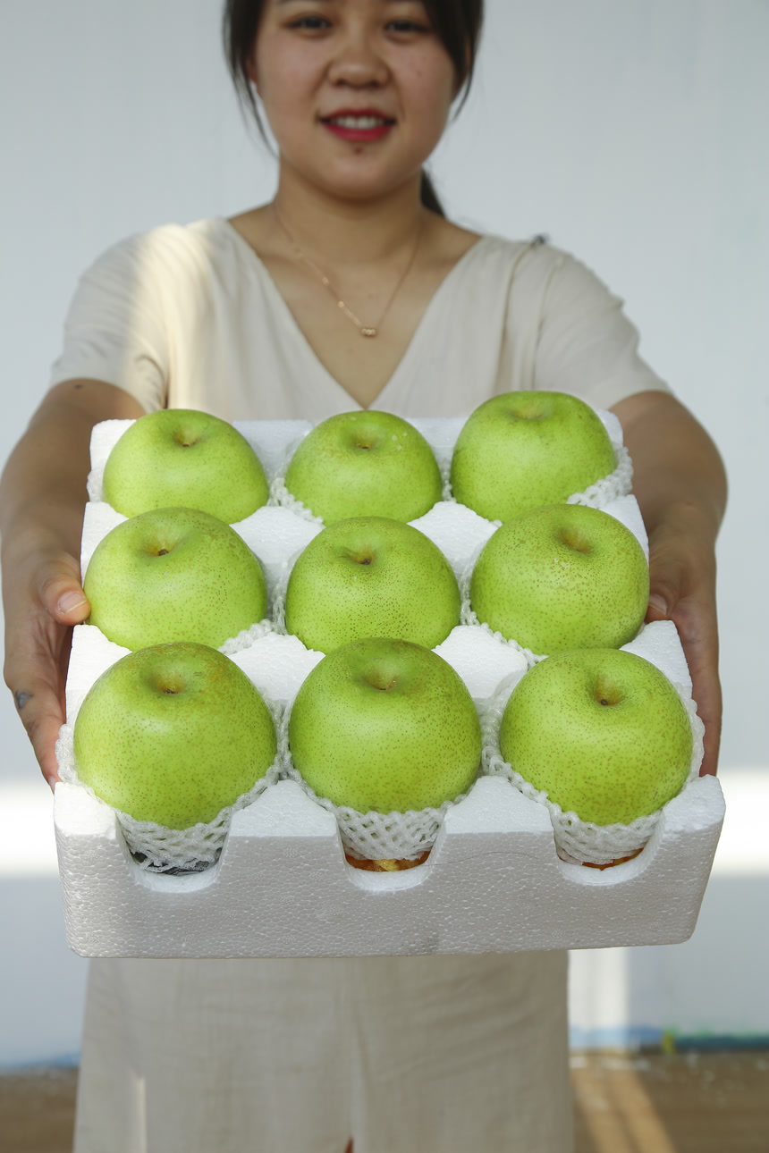 手里拿着一盒青皇冠梨