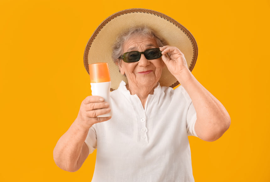 手拿防晒霜的老年妇女摄影图生活方式