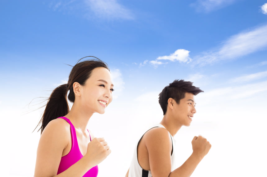 蓝色天空下快乐的年轻男女情侣快乐跑步健身锻炼身体