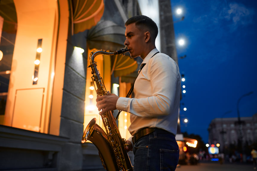 萨克斯风手晚上在街上演奏萨克斯风人物背景壁纸