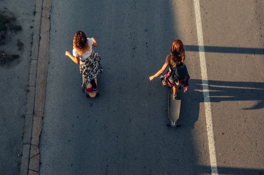 两个年轻女孩在路上玩滑板俯瞰图  年轻 活力 运动 概念