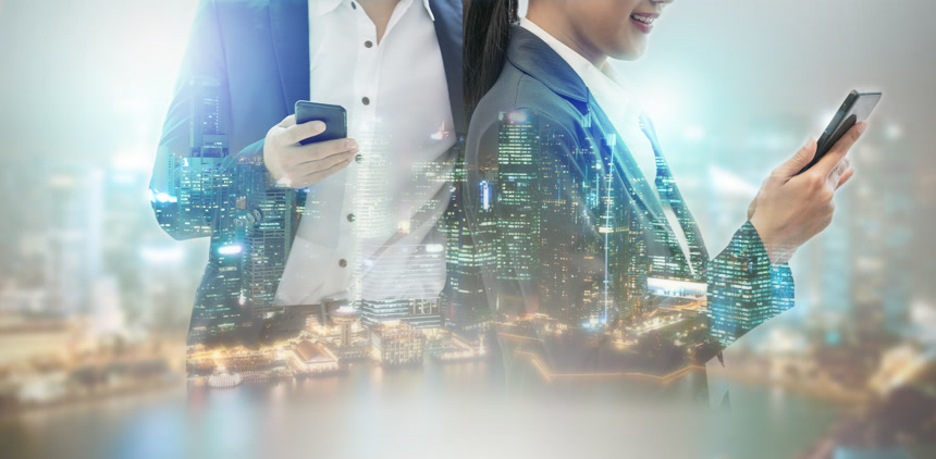 年轻的商界人士使用手机与现代城市建筑背景。未来电信技术与物联网概念.