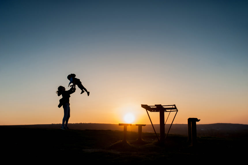 夕阳下母亲和儿童的剪影背景图片