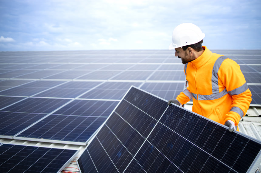 Industrial worker installing solar panels on the factory roof for inexpensive sustainable energy or electricity.太阳能板维修安装
