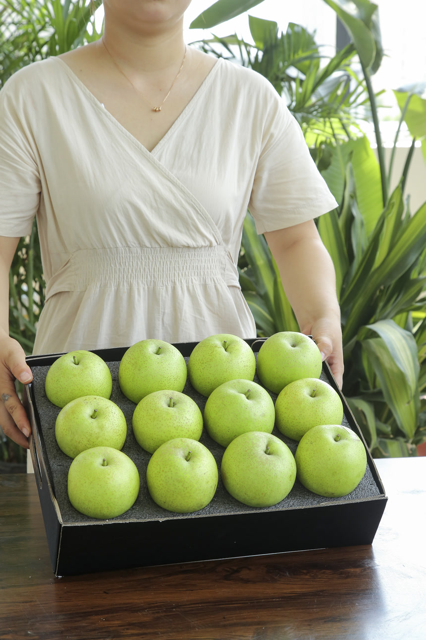 手里拿着一盒青皇冠梨