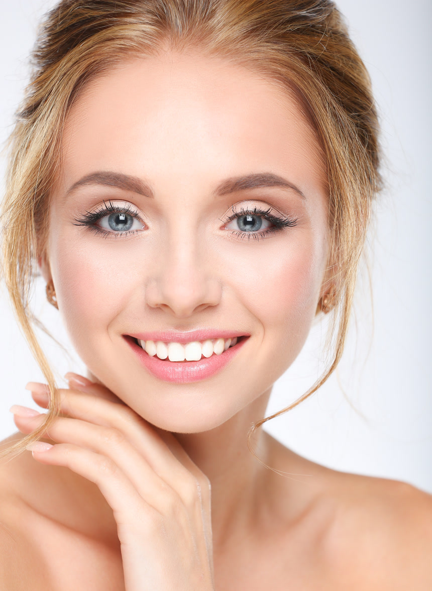 一位年轻女子在白色背景上抚摸着自己的脸特写美白护肤