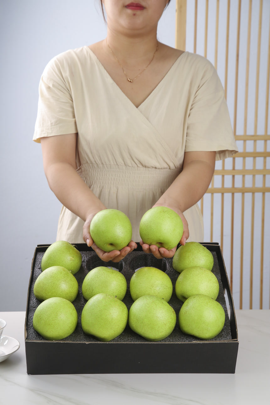 手里拿着一盒青皇冠梨