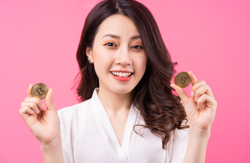 手里拿着比特币的亚洲女商人金融经济
