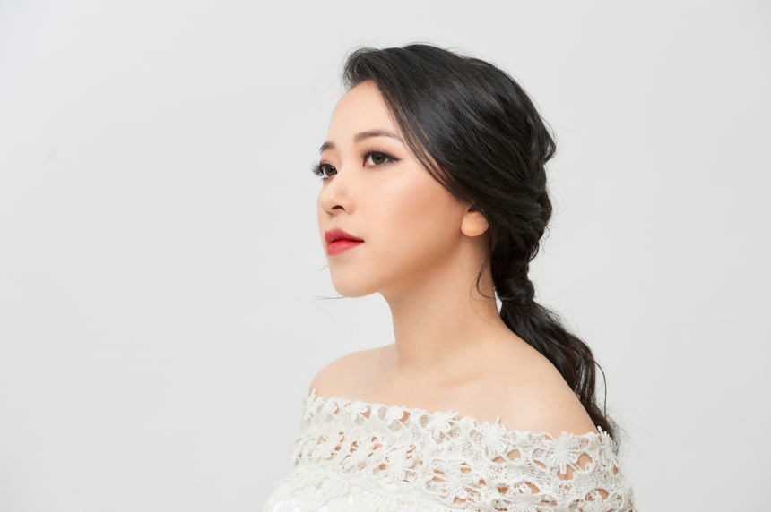 一位穿着白色婚纱画着精致妆容美丽新娘摄影棚拍摄