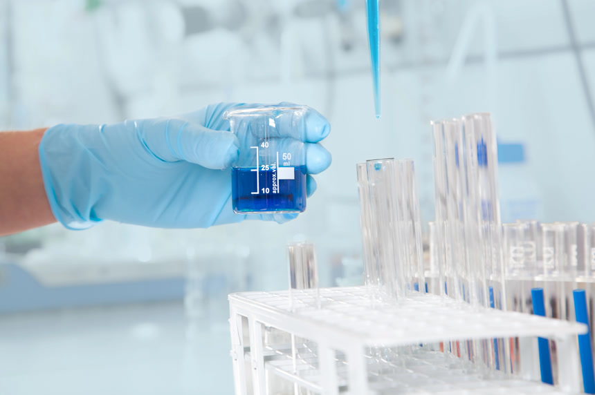 实验室手拿装有蓝色药剂的刻度杯医学医疗生物制药