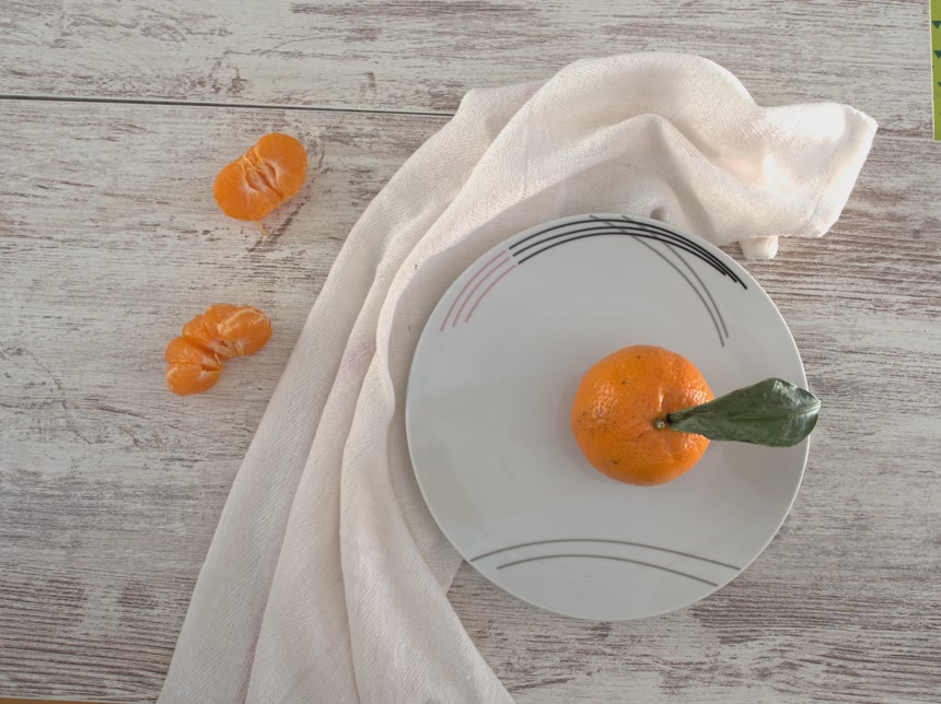 木桌上盘子里放着新鲜的有机桔子餐厅宣传