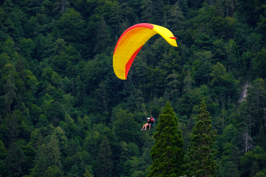 在多云的天空中飞行的串联滑翔伞极限运动