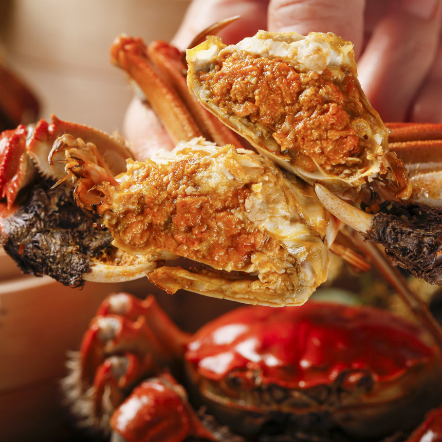 手里拿着清蒸大闸蟹