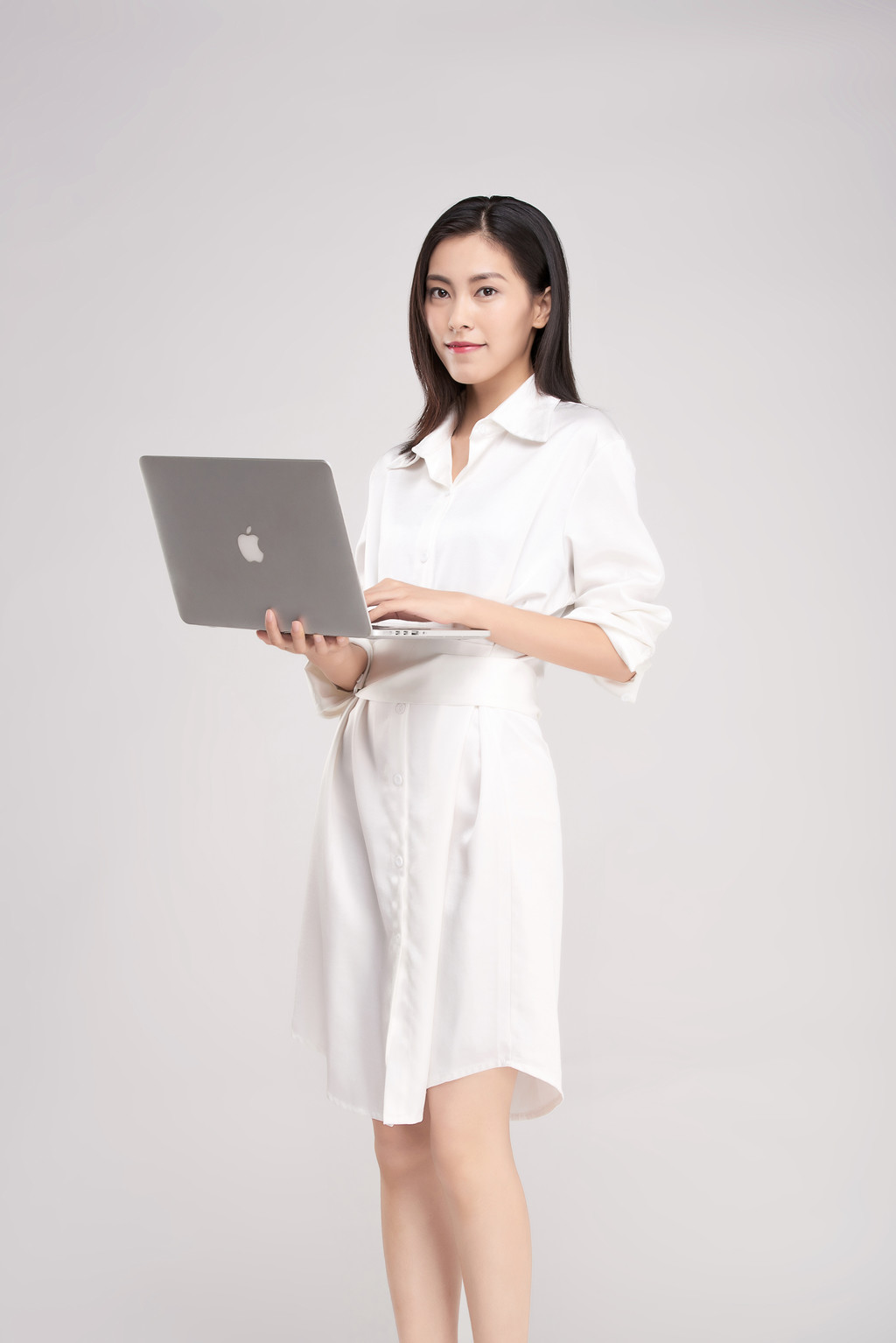 商务女性穿着连衣裙拿着电脑背景图片