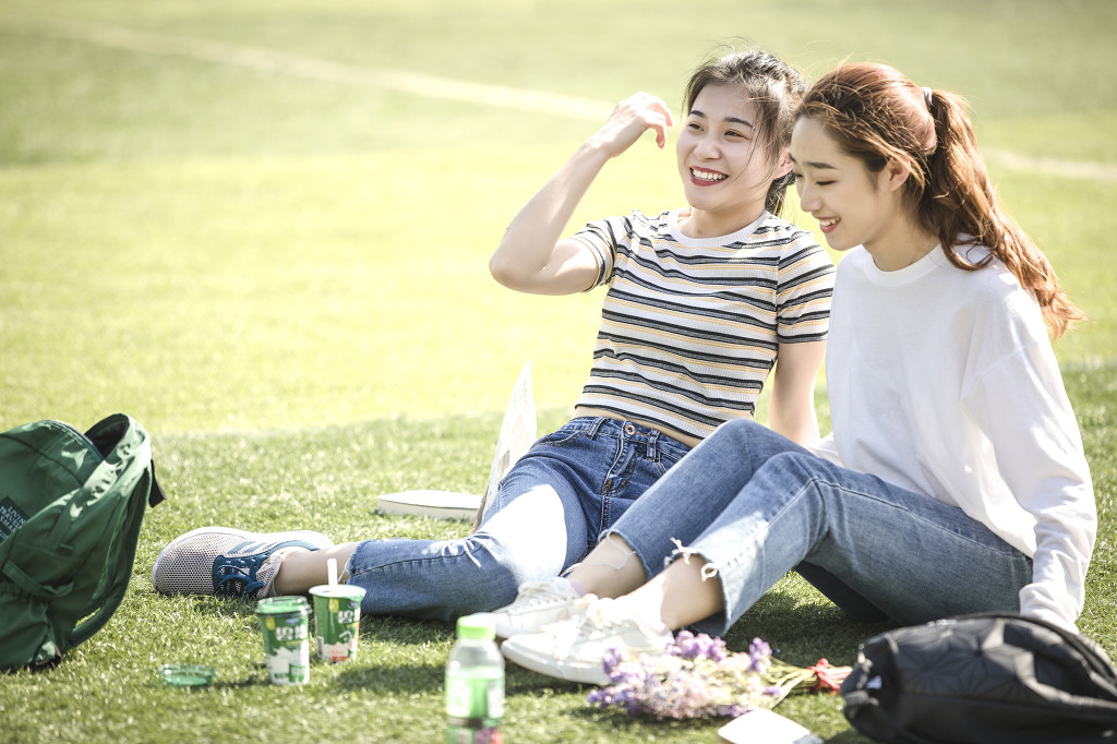 学生朋友在草坪上嬉戏读书图片