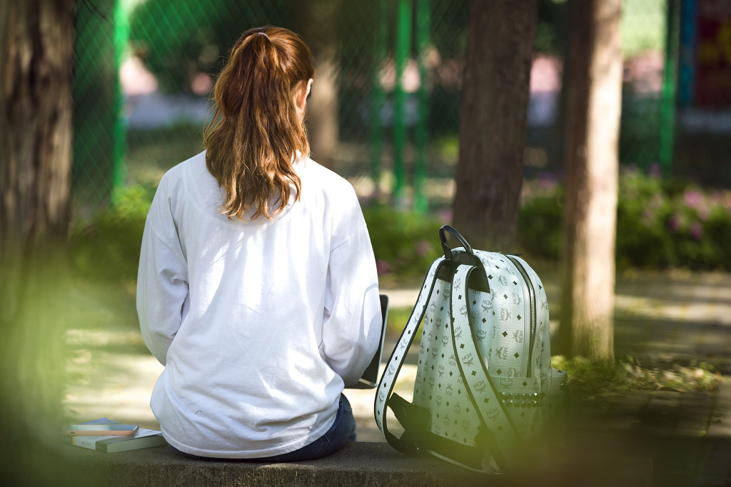 校园小路上朋友闺蜜坐在石板凳上背影图片