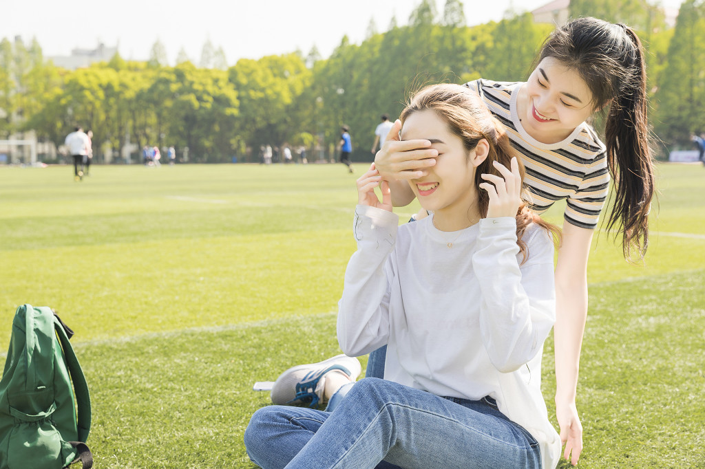 学生朋友在草坪上嬉戏图片