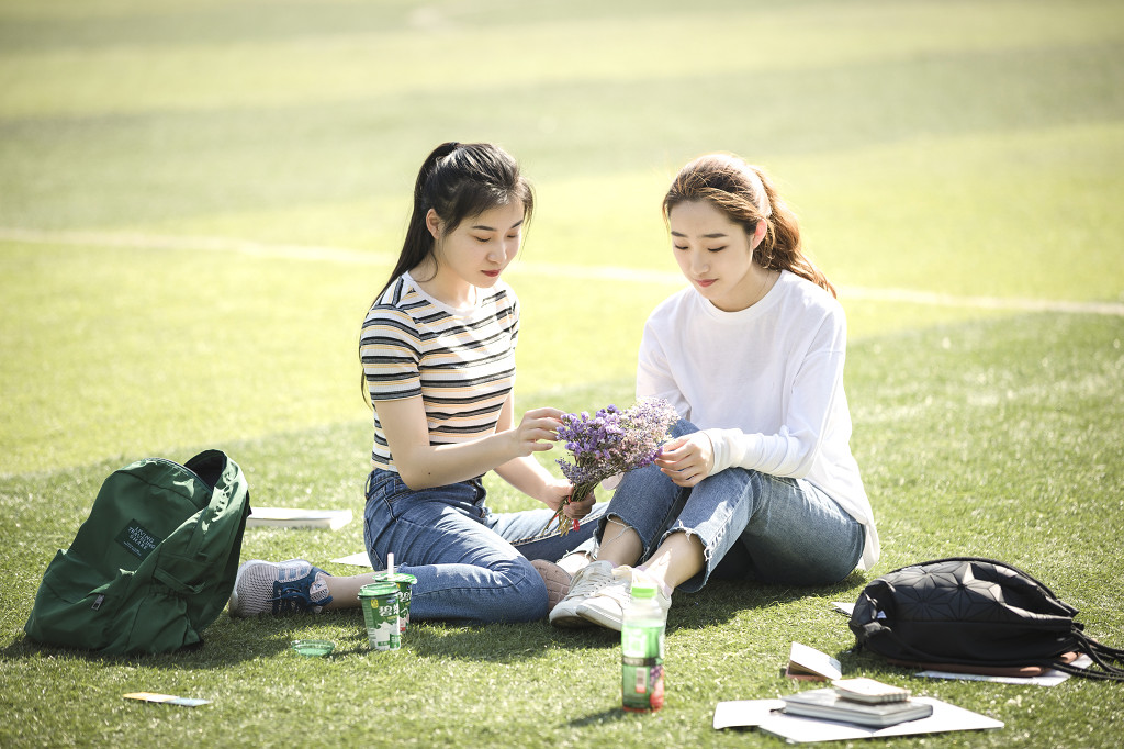 学生朋友在草坪上嬉戏图片