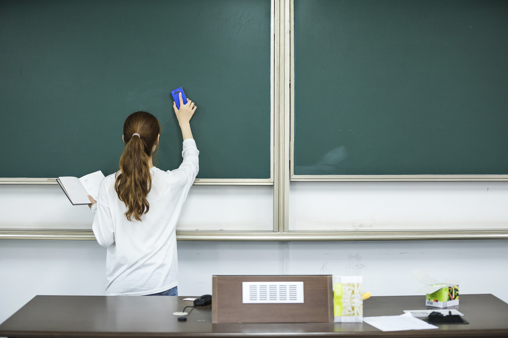 校园毕业季学生在黑板上写字